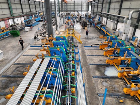 Aerial view of a large manufacturing plant interior with machinery and workers.